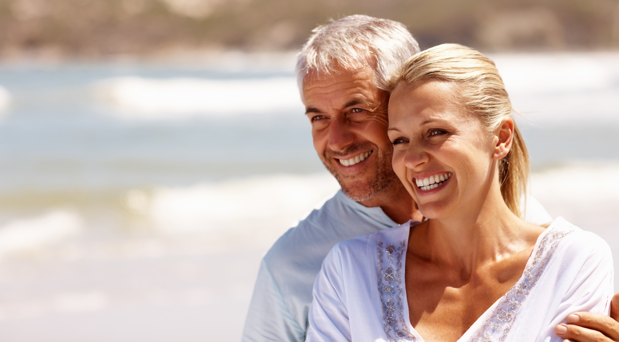 Happy mature couple embracing on a sunny day at the beach