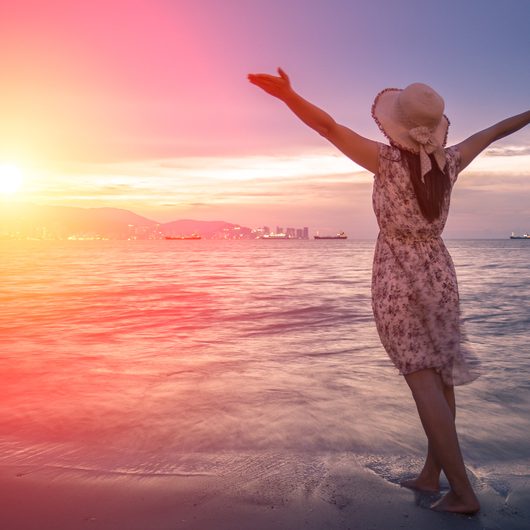 strong confidence woman open arms under the sunrise at seaside