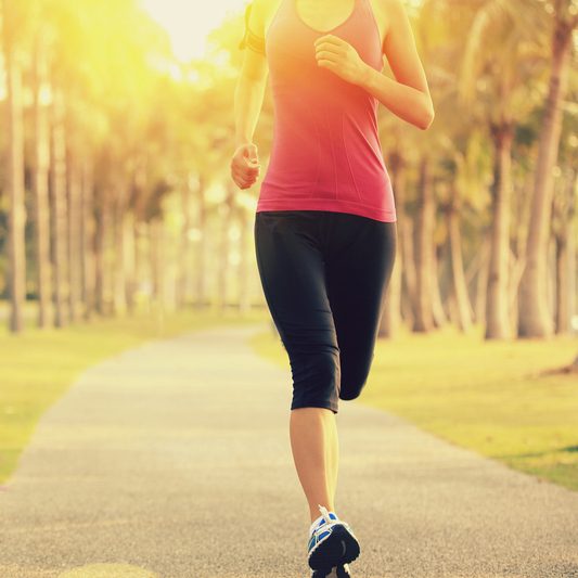 Girl running in the park with red top and black bottoms