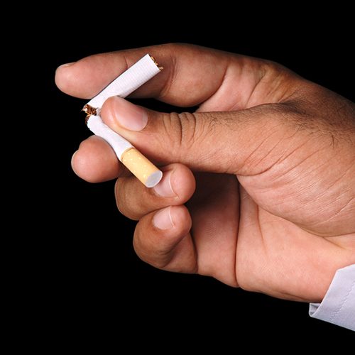 Mans hand breaking a cigarette