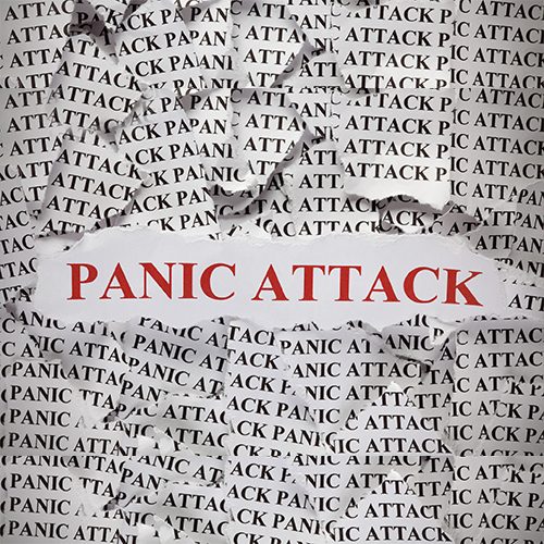 Torn pieces of paper with the word "Panic Attack". Concept Image. Close-up.